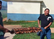 carrying the cooked chicken over to pack it